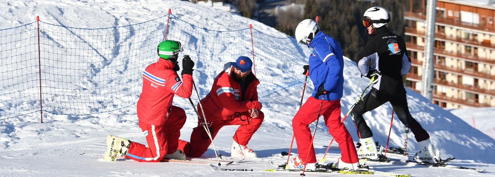 Deux moniteurs avec deux adolescents en cours de ski compétition