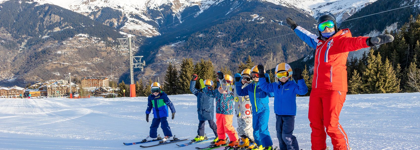 Groupe d'enfants en cours de ski avec une monitrice