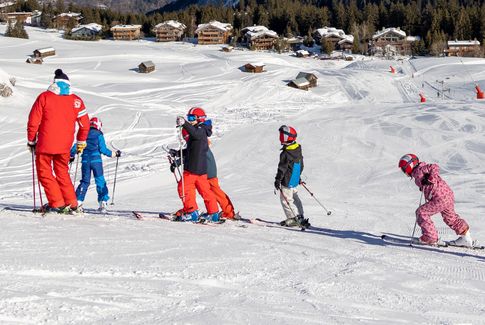 skieurs et moniteur en cours de ski enfant