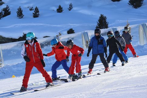 Monitrice de ski avec un groupe enfant