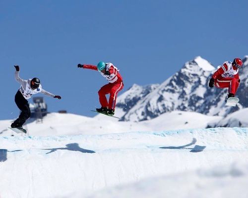 Moniteur de snow avec un élève dans un snowboardcross